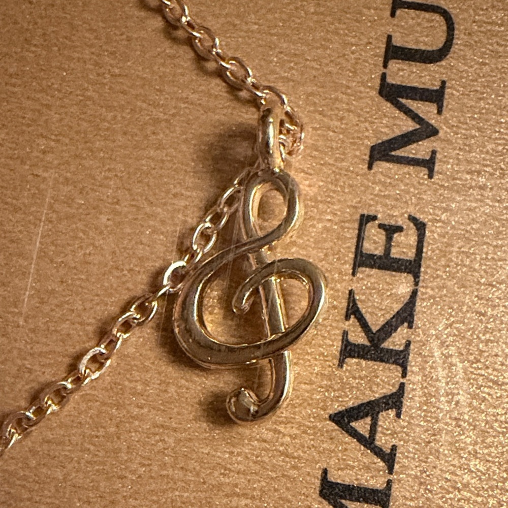 New in package gold treble clef necklace